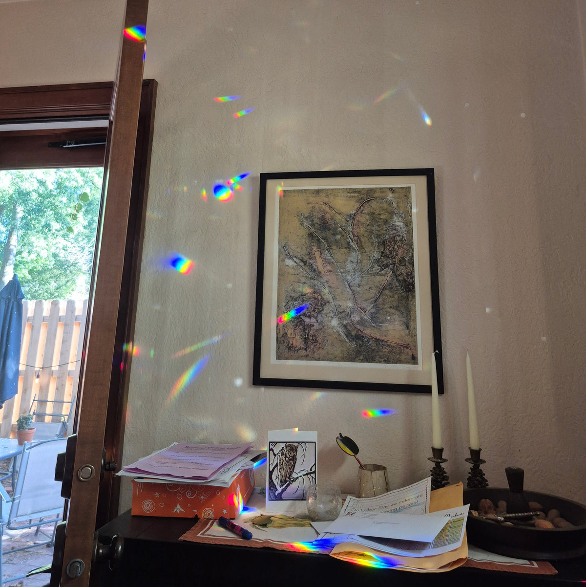 prismatic refracted light in disbursed color bands resting on wall and desk