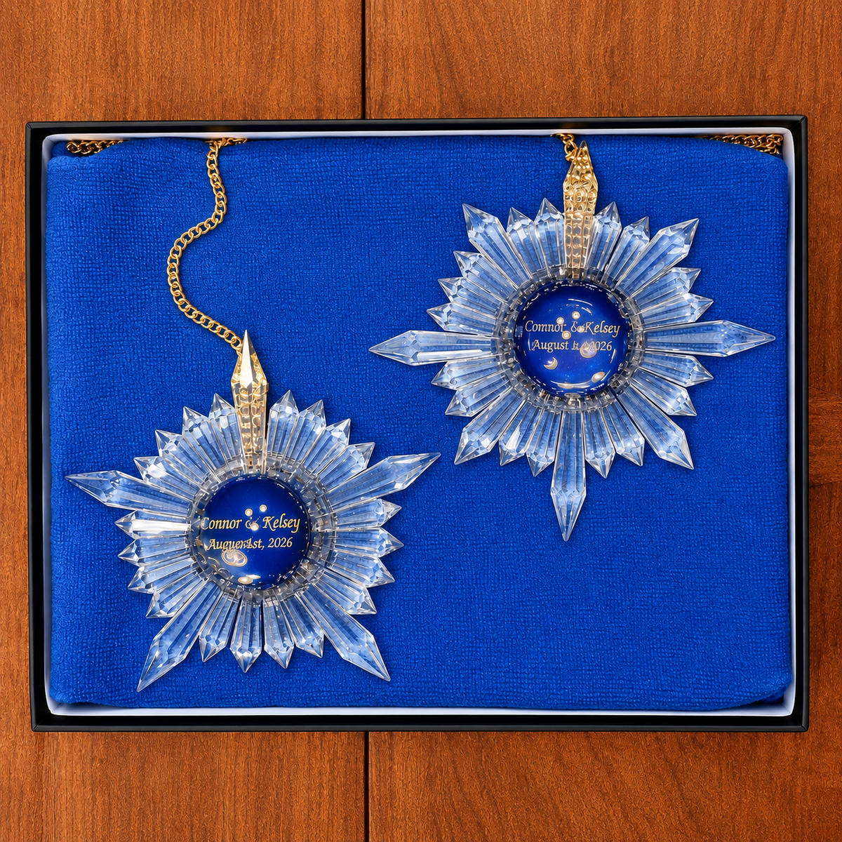 a beautiful display box with blue cloth having two special edition star-shaped prism suncatchers with engravings of names and wedding date