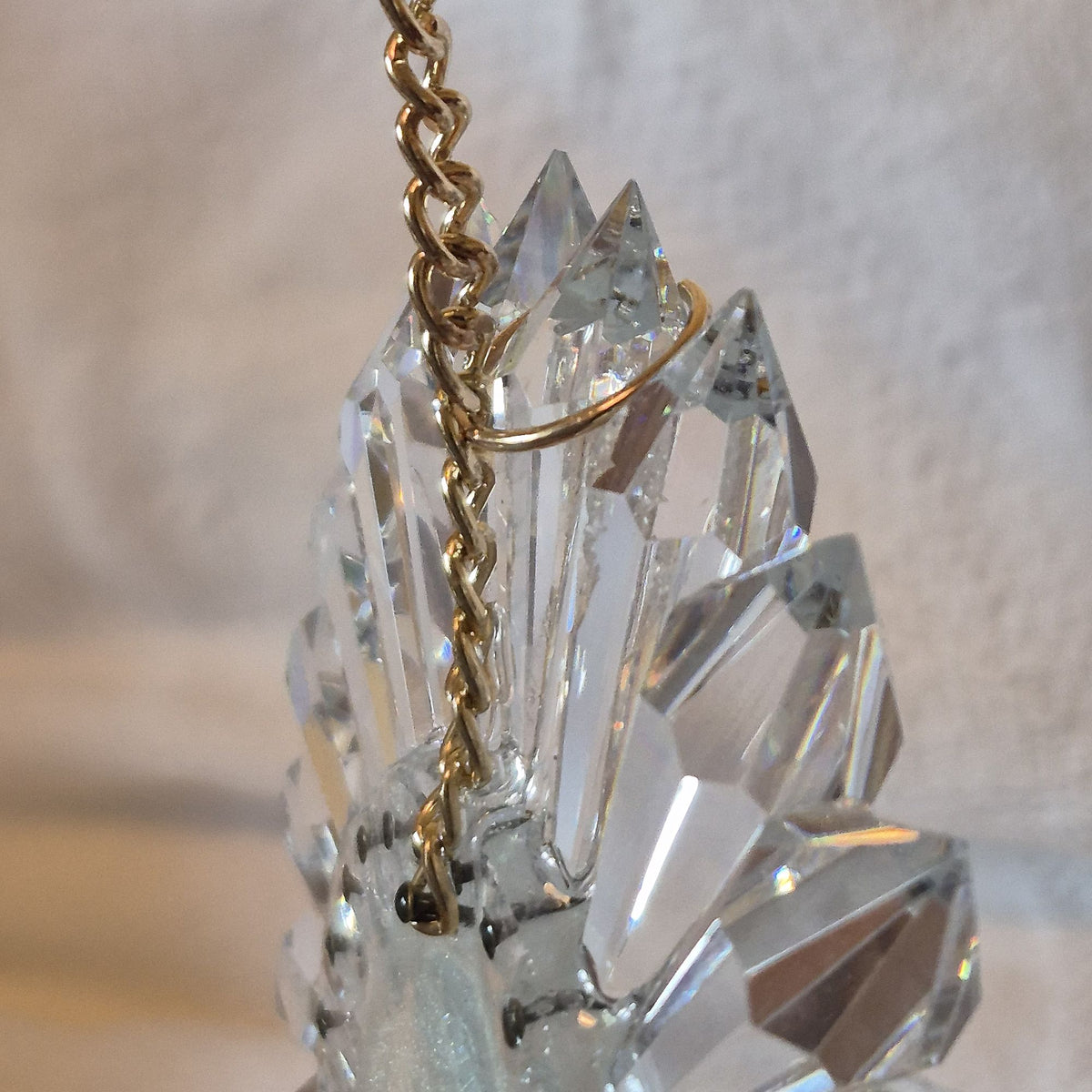 close view of lead crystal prisms assembled with gold chain attached and kept with a gold ring