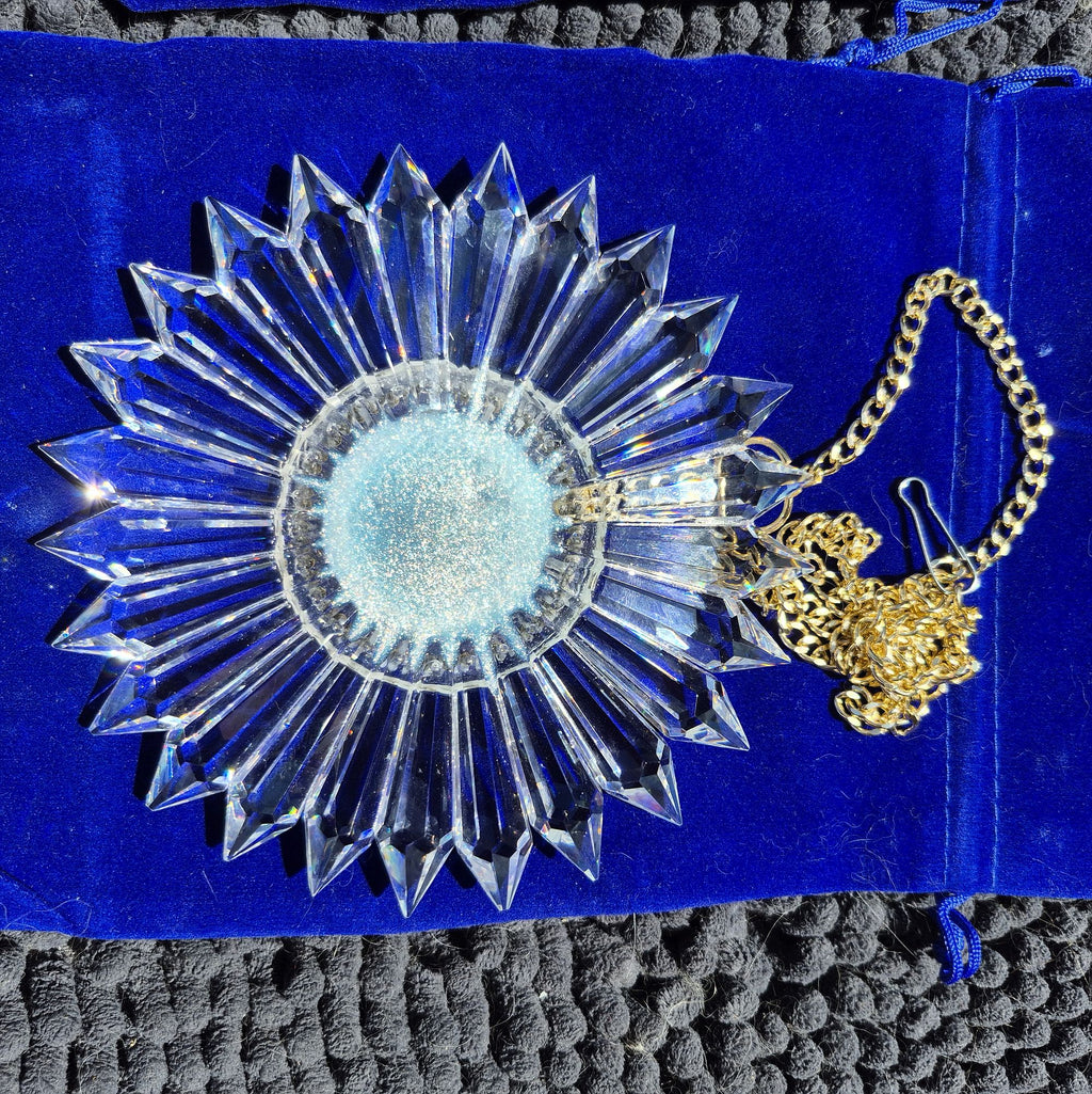 6-inch prism suncatcher with a gold chain on a blue background having an iridescent opaque center