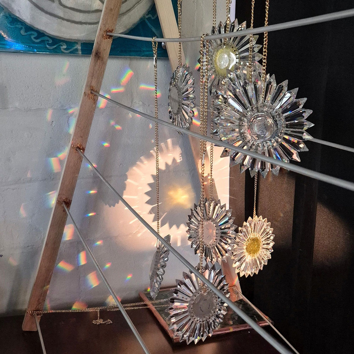a rack with lights shining on several prism suncatchers in a random pattern