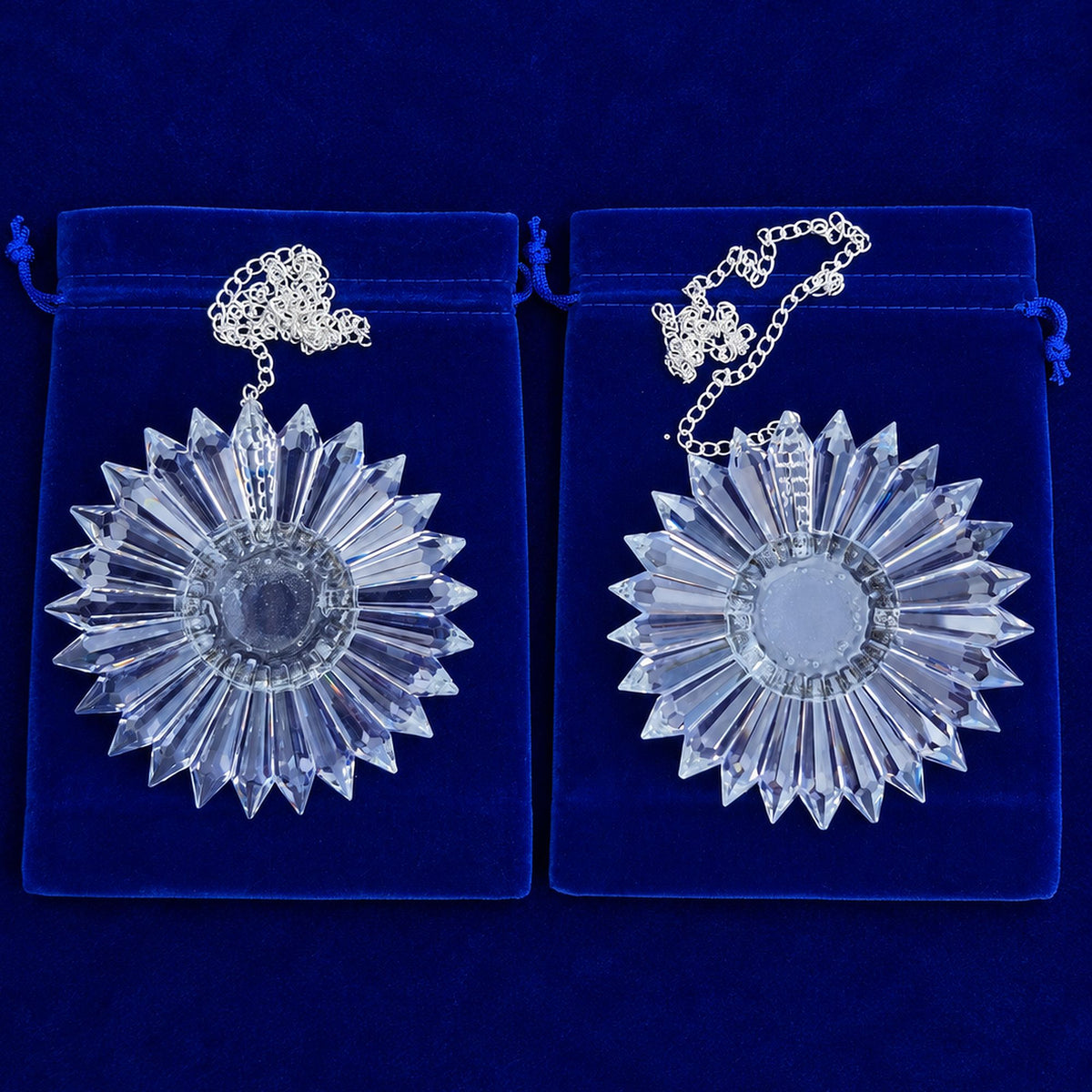 two clear 6-inch diameter prism suncatchers with silver-colored chains resting on a blue background