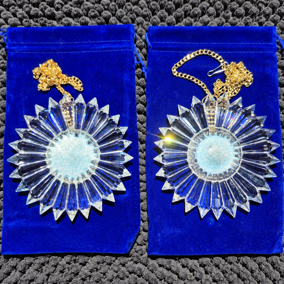 two iridescent filled centers of 6-inch prism suncatchers lying on blue velvet in the afternoon sun