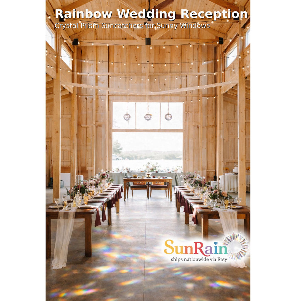 A wedding reception venue with long tables set down the center aisle, decorated with white tablecloths and floral arrangements. Large windows at the back show an outdoor view, and rainbow light projections dance across the floor.
