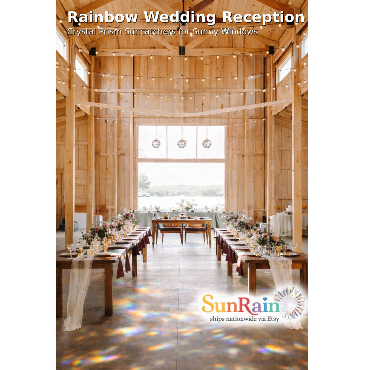 A wedding reception venue with long tables set down the center aisle, decorated with white tablecloths and floral arrangements. Large windows at the back show an outdoor view, and rainbow light projections dance across the floor.