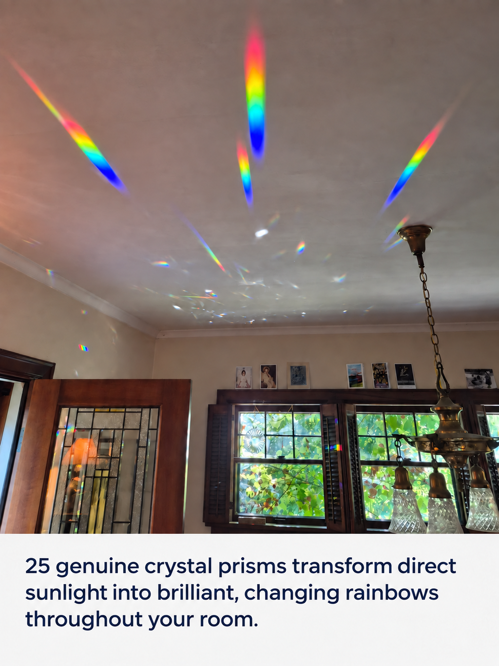 A home interior with sunlight streaming through windows and creating rainbow light patterns on the ceiling and walls. Text at the bottom reads: '25 genuine crystal prisms transform direct sunlight into brilliant, changing rainbows throughout your room.
