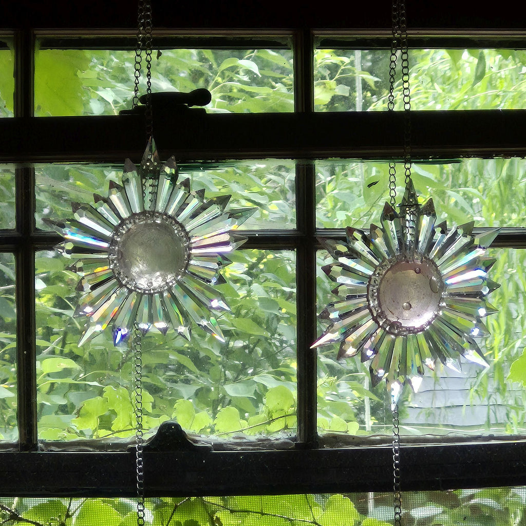 two pink bubble designs over center of star-shaped prism suncatchers hanging in a divided glass wood frame window