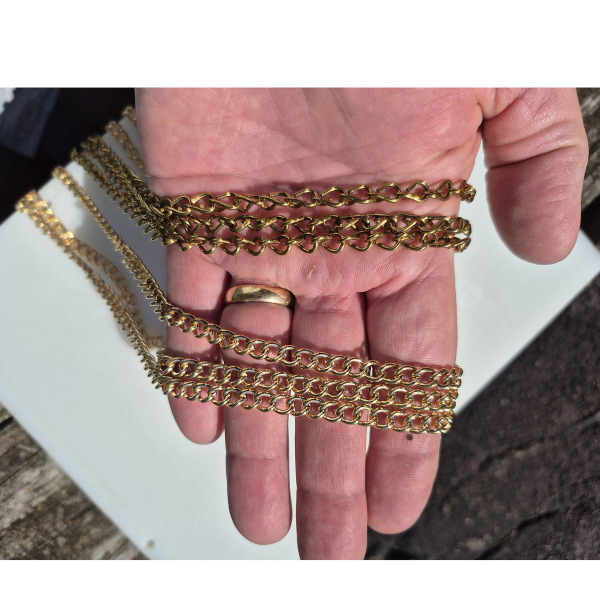 hand holding two styles colors of extension chain, one is bronze and the other is gold