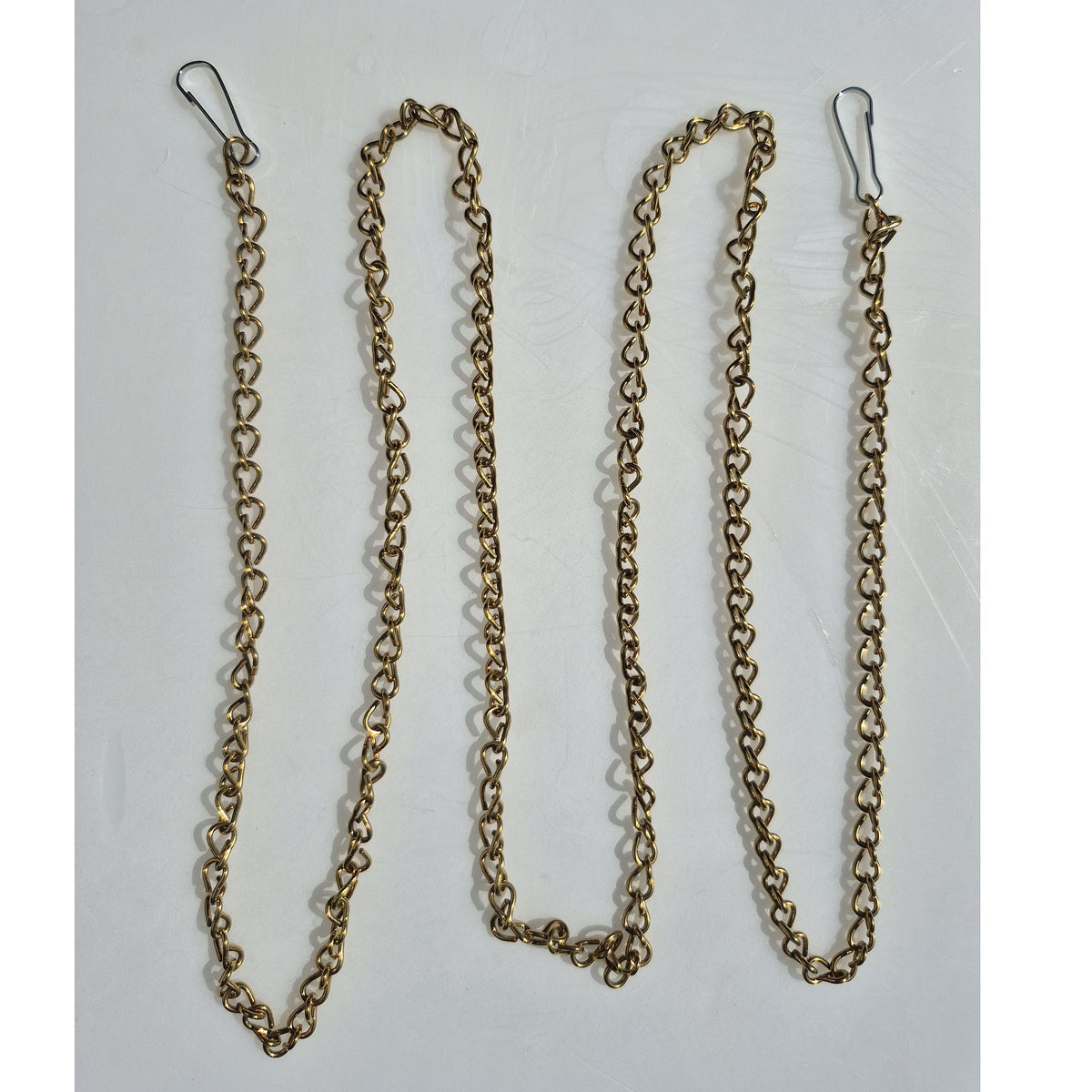 bronze chain with lanyard clips on either end laid out on table in zig zag pattern