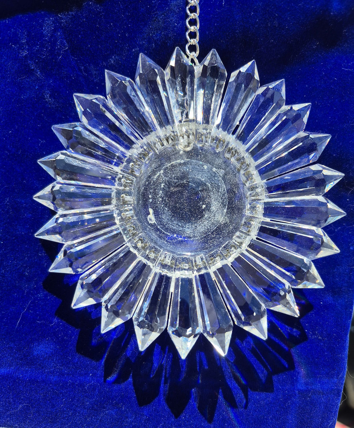 a sparkling 5-inch prism suncatcher on a blue velvet bag