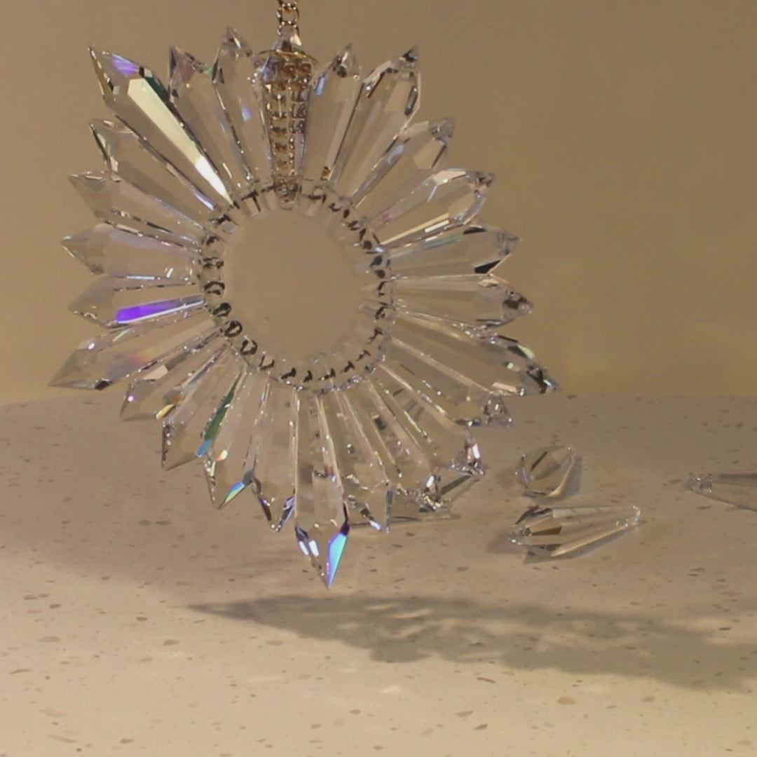a video of a star-shaped prism suncatcher over a marble slab in front of illuminated background.